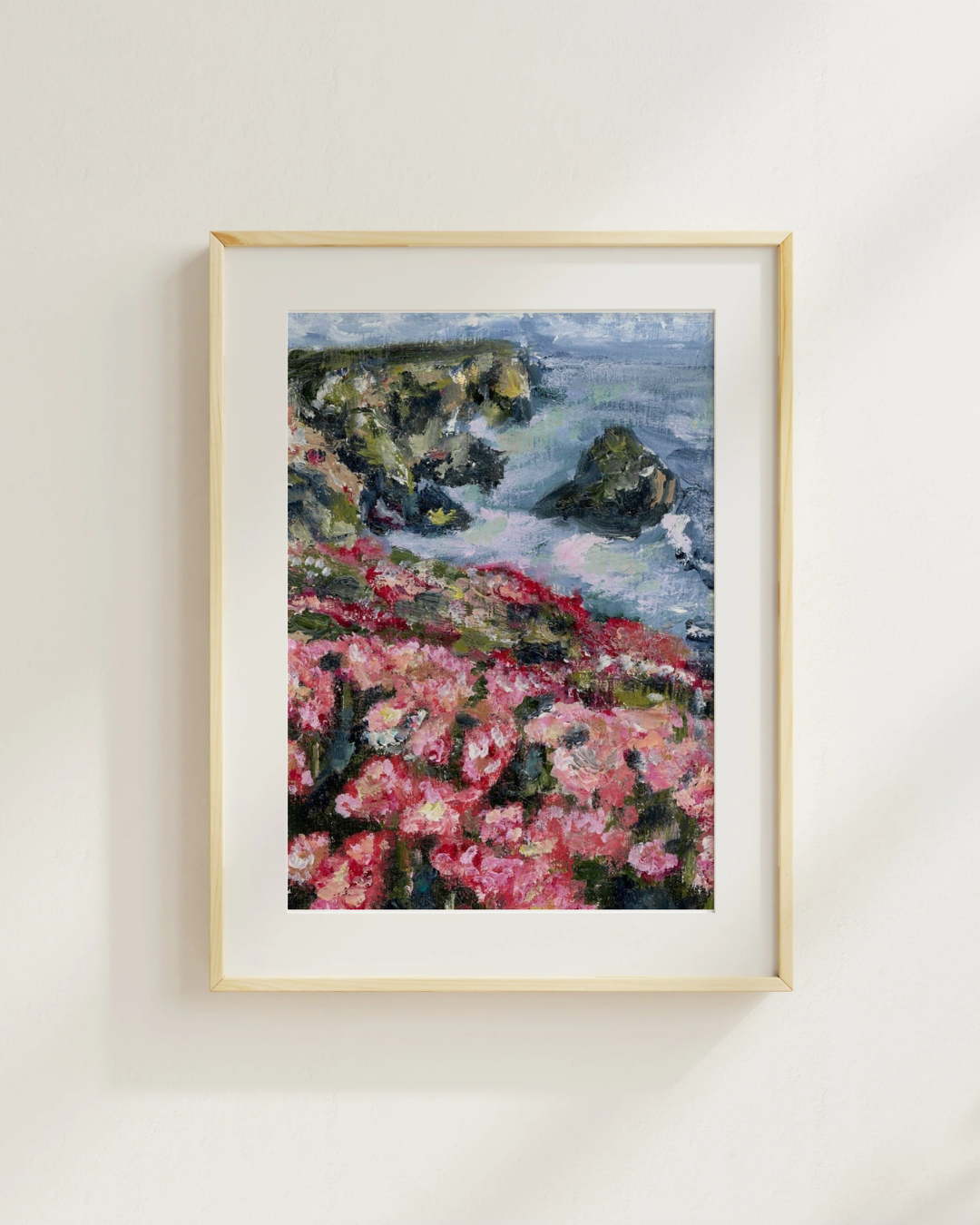 Rose Cliffs coastal print with pink flowers in a light wood frame